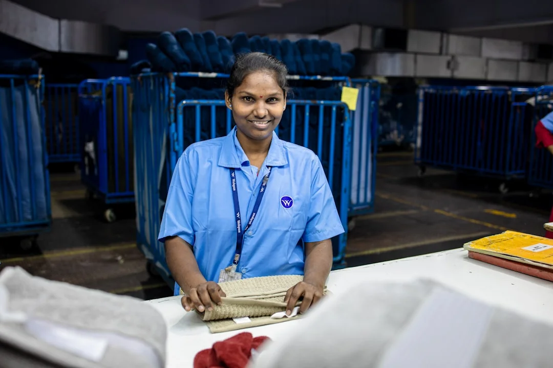 Une femme enveloppe avec soin un canapé dans un matériau de protection tout en préparant des cartons dans une pièce lumineuse.